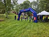 Deltakere ved en SpareBank 1-bue og telt i en grønn park.