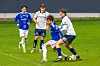 Fotballspillere i blå og hvite drakter duellerer om ballen på gresset.