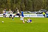 Fotballspillere i blått og hvitt i en duell på en grønn gressbane.