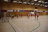 Håndballballspillere i aksjon i en stor innendørs idrettshall.
