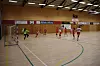 Håndballballspillere i aksjon i en stor innendørs idrettshall.