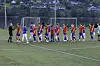 Ungdomsspillere i røde og blå drakter står samlet på en fotballbane.