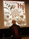 Mann står foran en projisert bokforside med tittelen «Andre verdenskrig».