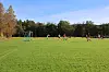 Fotballkamp på gressbane med Rindal IL-spillere i angrep foran mål.