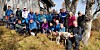 Gruppe turgåere poserer utendørs i skogen sammen med to hunder.
