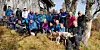 Gruppe turgåere poserer utendørs i skogen sammen med to hunder.