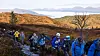 Turgåere i fargerike jakker følger en sti gjennom høstfjellet.