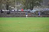 Fotballspiller i blått og hvitt på en gressbane foran tilskuere.
