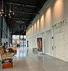 Moderne korridor med sitteplasser, utstillinger og skilt til operasalen.