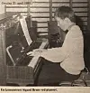 Svart-hvitt foto fra en avis; av en person som spiller piano. Ribbvegger bak.