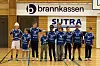 Ungt håndballag i blå drakter poserer på en innendørs bane.
