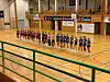 To håndballag står på rekke i en innendørs idrettshall.