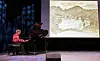 Pianist ved flygel på scene med projisert fjellillustrasjon i bakgrunnen.