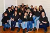 Gruppe voksne poserer sammen i et lyst rom med tregulv.