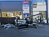 Landbruksmaskiner og butikkansatte utenfor en butikk.