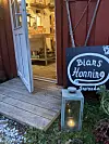 Åpen butikkdør med skiltet «Bians Honning», lykt og produkter synlige innenfor.