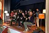 En gruppe musikere spiller sammen på en liten, opplyst scene.