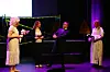 Fire personer på en lillaopplyst scene. En mann utkledd som brud, ei som programleder, en som brudgom og ei som prest.