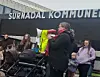 Folkemengde utenfor Surnadal kommune med barnevogn og person i refleksvest.