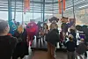 Publikum ser på fargerike kostymerte figurer på en liten scene i et lyst lokale.